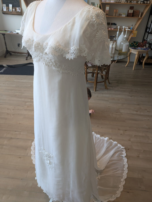 Pine Eco + Refillery Boutique vintage-inspired white wedding gown with delicate floral lace appliqué and sweeping train