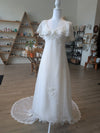 Pine Eco + Refillery Boutique vintage-inspired white wedding gown with delicate floral lace appliqué and sweeping train